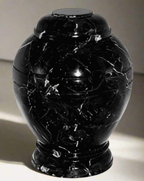Round marble urn with black and white finish.