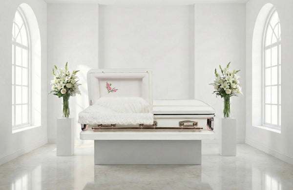 White casket in a bright, minimalistic room with floral arrangements.