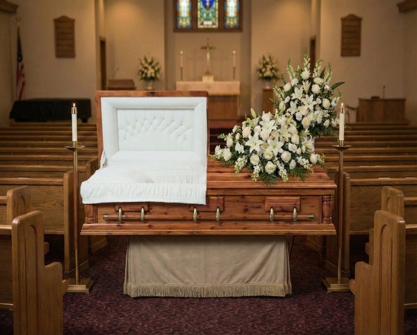 Casket in a church setting with flowers and candles