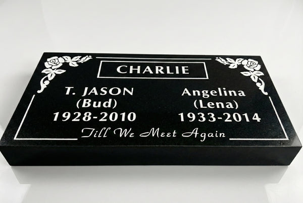 Black granite marker with engraved names and dates on a white background