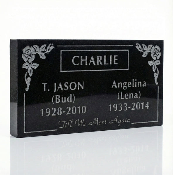 Black granite headstone with engraved names and dates on a white background