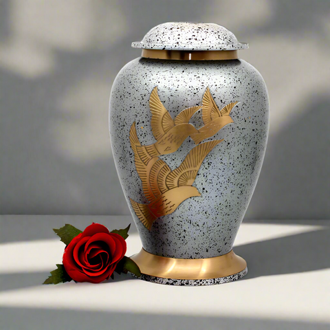 Brass metal urn with golden doves on the surface