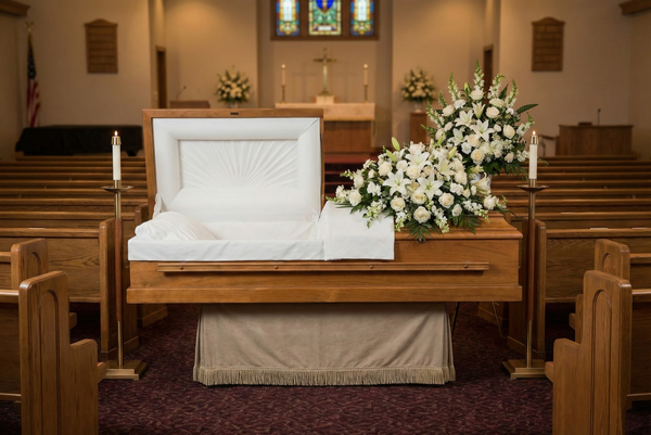 Casket with floral arrangements in a church setting