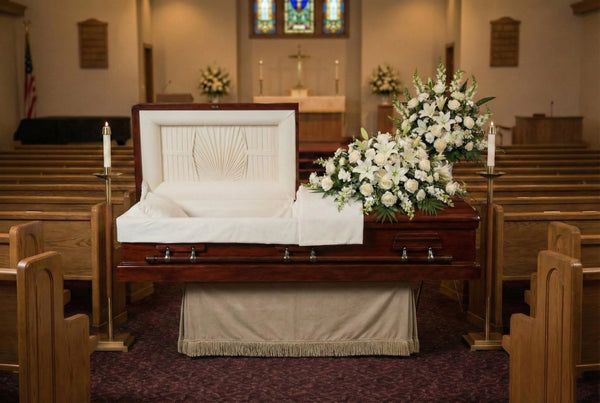 Premier Mahogany casket in a funeral home with flowers and candles