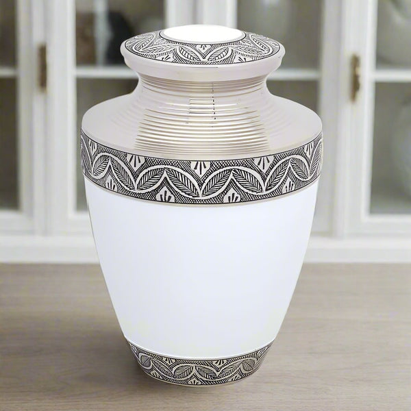 White metal urn with silver bands displayed in a home with soft grey wood flooring